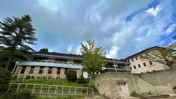 A building with a stone facade, multiple windows, and a flat roof.