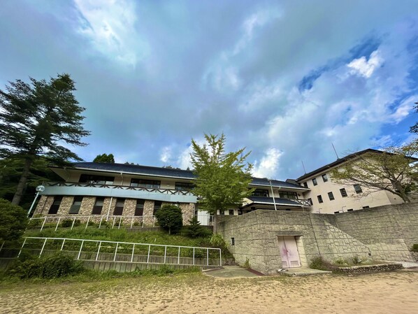 A building with a stone facade, multiple windows, and a flat roof.