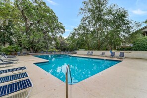 A swimming pool with lounge chairs and trees in the background. - Walk to Beach & Golf | 2 BR Palmetto Dunes Villa (Hilton Head Island)
