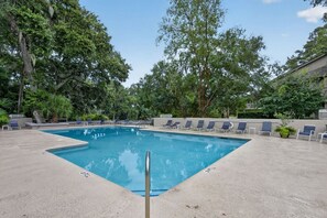A rectangular swimming pool with a concrete deck, surrounded by lounge chairs and trees. - Walk to Beach & Golf | 2 BR Palmetto Dunes Villa (Hilton Head Island)