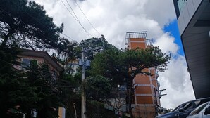 A concrete pathway leading to a building with a brick facade and a large window. - RM Grandview Residences (Baguio)