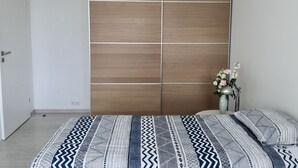 Une chambre à coucher avec un lit, une armoire et un vase rempli de fleurs.