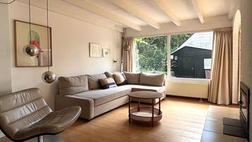 Uma sala de estar com sofá, poltrona e mesa de centro.