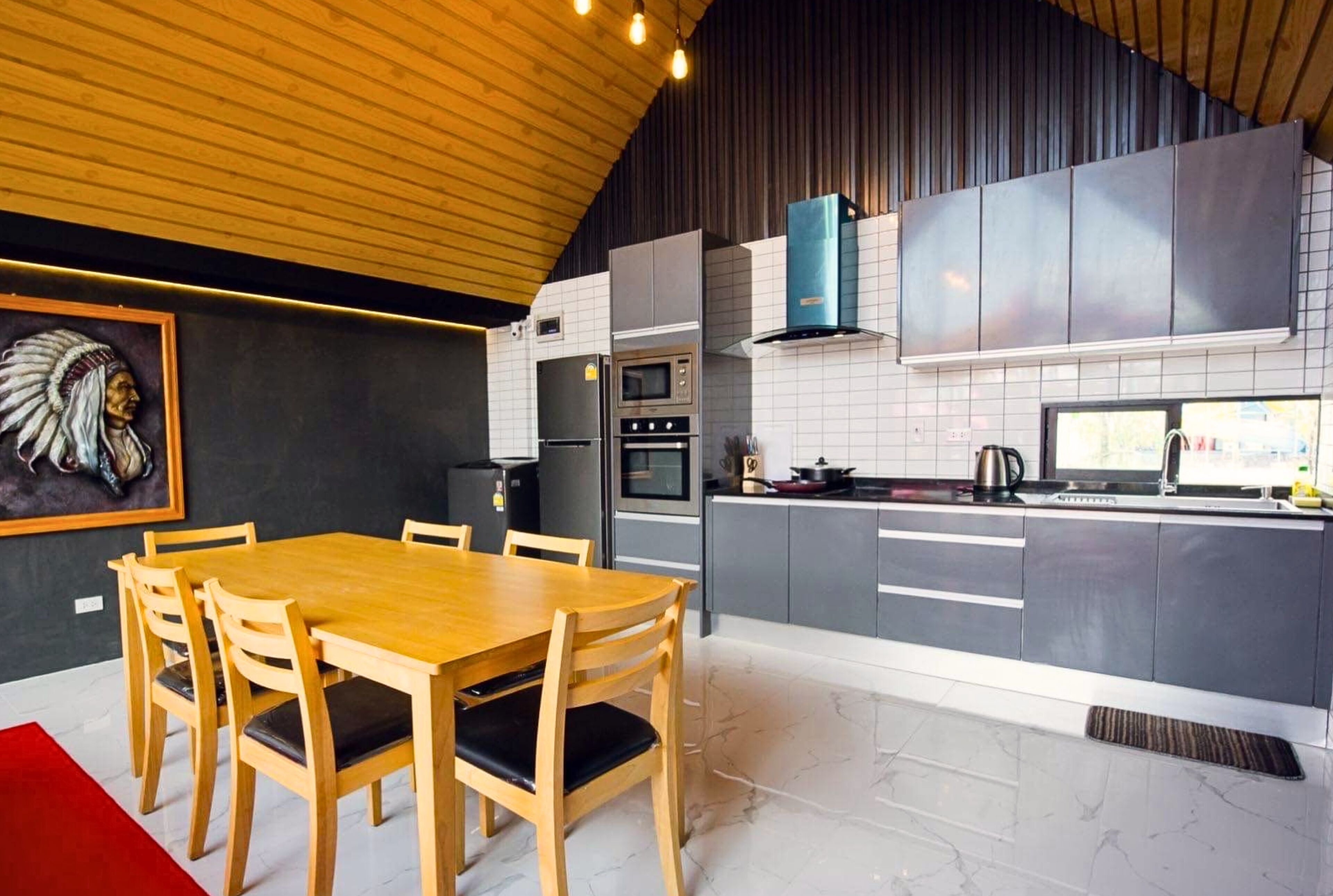 Eine moderne Küche mit grauen Schränken, einem Holztisch und einer schwarz-weißen Küchenrückwand.