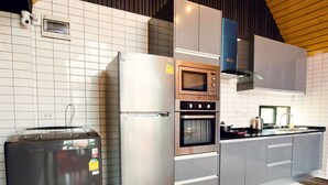 A modern kitchen with a stainless steel refrigerator, built-in oven, and microwave. - NP Pool Villa Hua Hin (Hua Hin)