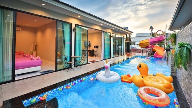 A modern hotel with a swimming pool, glass doors leading to a bedroom, and a slide. - NP Pool Villa Hua Hin (Hua Hin)