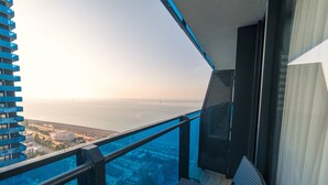 A balcony with a view of the ocean and cityscape. - Grand City Real Estate (Batumi)