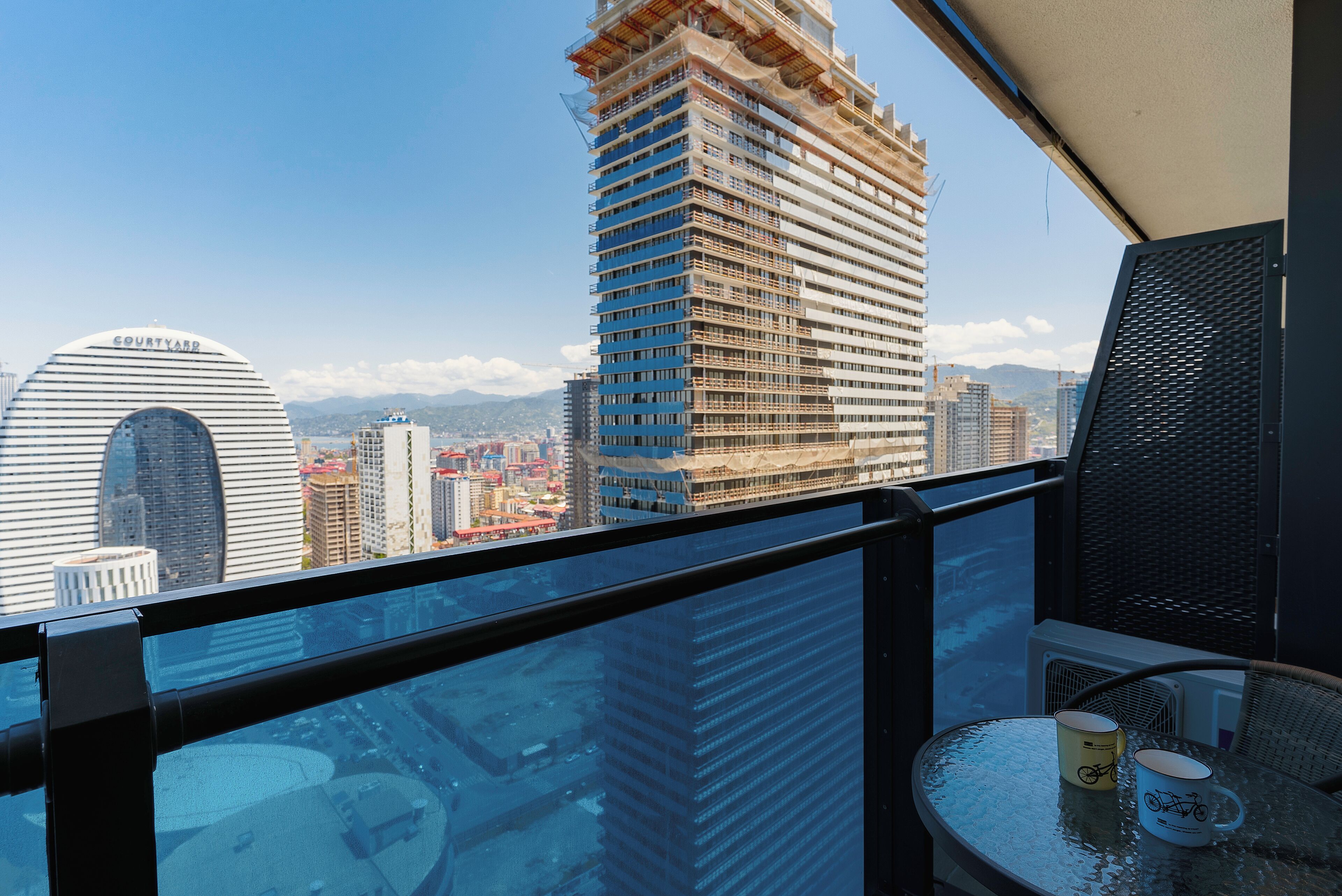 A high-rise building under construction with a view of the cityscape.