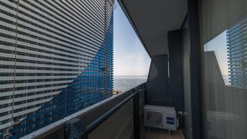Un balcón con vistas a un edificio moderno y al mar.