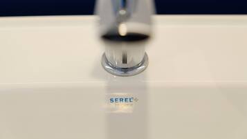 A bathroom sink with a faucet and the brand name SEREL Hygiene visible on the surface.