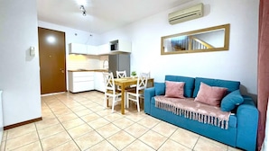 A compact living space with a kitchenette, a dining area, and a sofa. - Gorgeous Caorle resort near the beach (Caorle (VE))