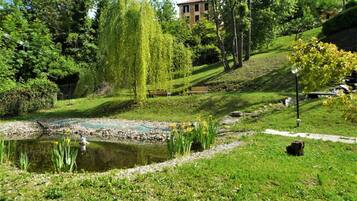 Ein friedlicher Park mit Teich, Bänken und einer Weide.