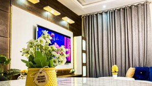 Ein Wohnzimmer mit einem Marmortisch, einem Fernseher und einem Sofa.