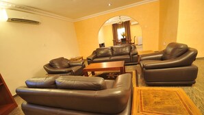 Ein Wohnzimmer mit Ledersofas, einem Holztisch und einem Teppichboden.