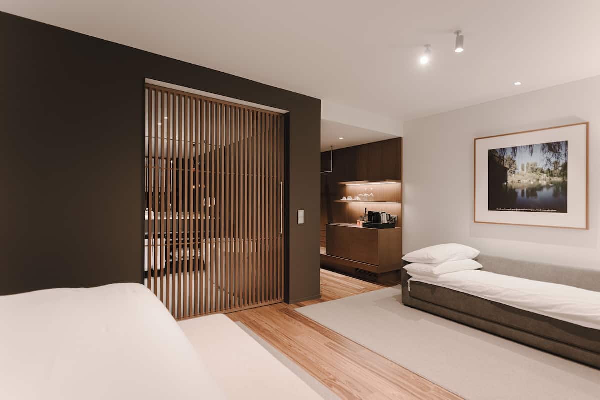 A modern bedroom with a bed, a wardrobe, and a desk area.