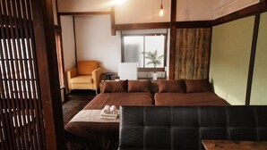 Una habitación moderna con sofá, sillón, una mesita y ventana con vistas al exterior.
