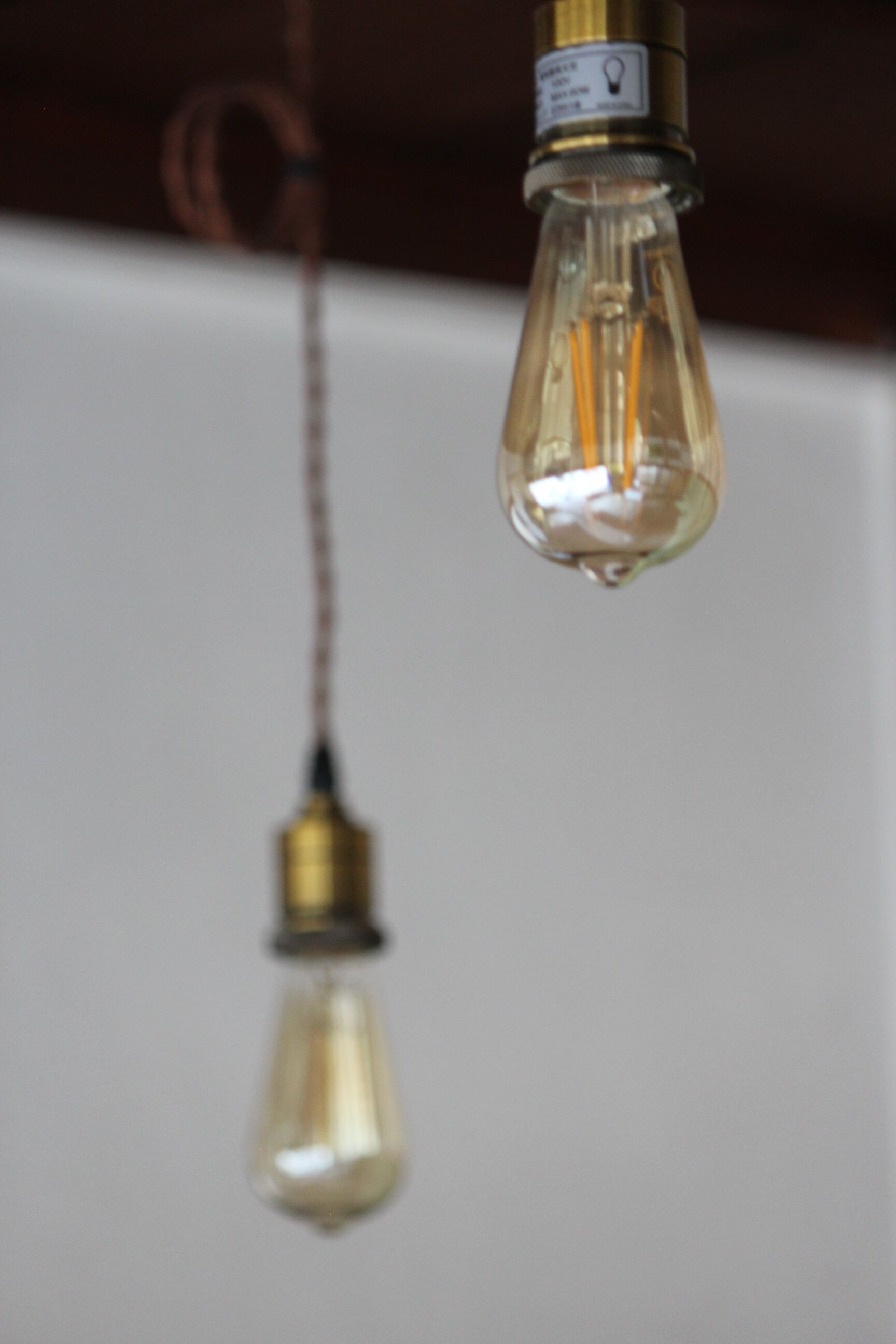 A close-up of a light fixture with a clear glass shade and a brass base.