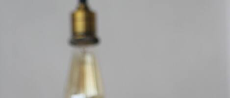 A close-up of a light fixture with a clear glass shade and a brass base.