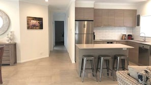 Enjoy cooking in this well-equipped kitchen with a refrigerator, stove, and bar area.