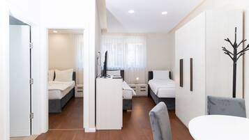 A modern, well-lit room with a bed, a desk, and a chair.