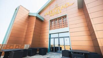 Exterior del hotel Meethao con un diseño moderno, destacando una entrada principal y un área de estar al aire libre.