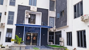 A modern building with a blue entrance, air conditioning units, and a sign that reads "HABAB". - HABAB GRAND RESORT (Abuja)