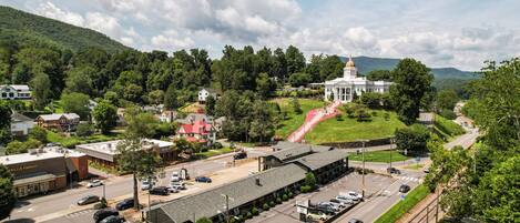 Un hôtel doté d’un grand parking, d’un bâtiment surmonté d’un dôme et offrant une vue sur une colline verdoyante.