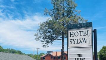 A sign for Hotel Sylva with a bear illustration and the text "YOU BELONG HERE".