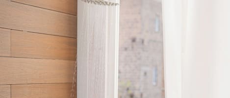Un baño con pared de madera, cabezal de ducha y bañera.