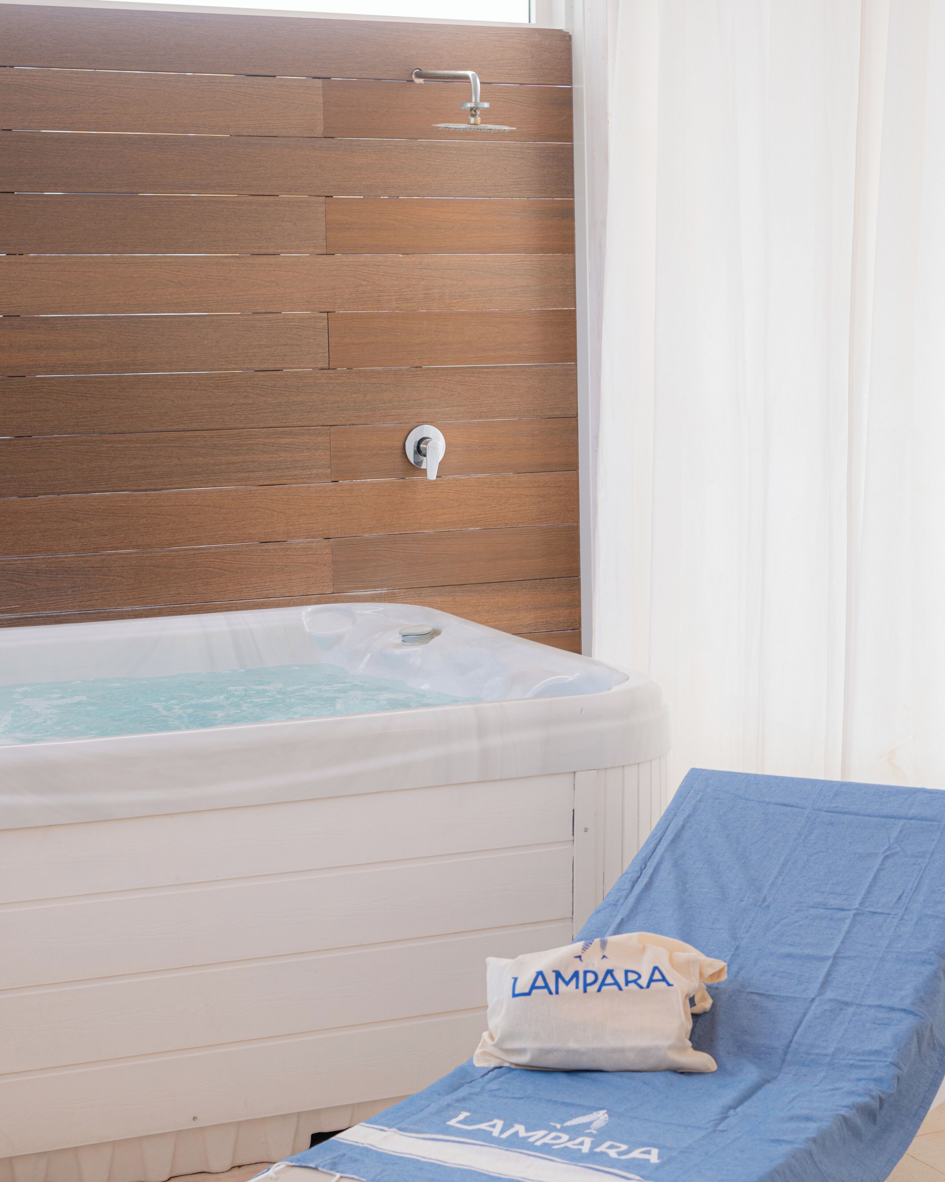 Un espace spa avec un mur en bois, un jacuzzi et une serviette sur laquelle est inscrit le mot « LAMPARA ».