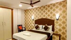 A bedroom with a bed, a ceiling fan, a wardrobe, and a chair. - Aashrey Bed and Breakfast (Port Blair)