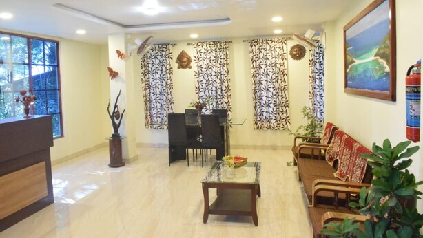 A reception area with a reception desk, seating area, and decorative curtains. - Aashrey Bed and Breakfast (Port Blair)