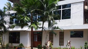 A building with a white exterior, a large window, and a signboard. - Aashrey Bed and Breakfast (Port Blair)