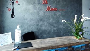 A reception desk with a calendar, a bottle of hand sanitizer, and a plant. - Magia di Mare (La Spezia)