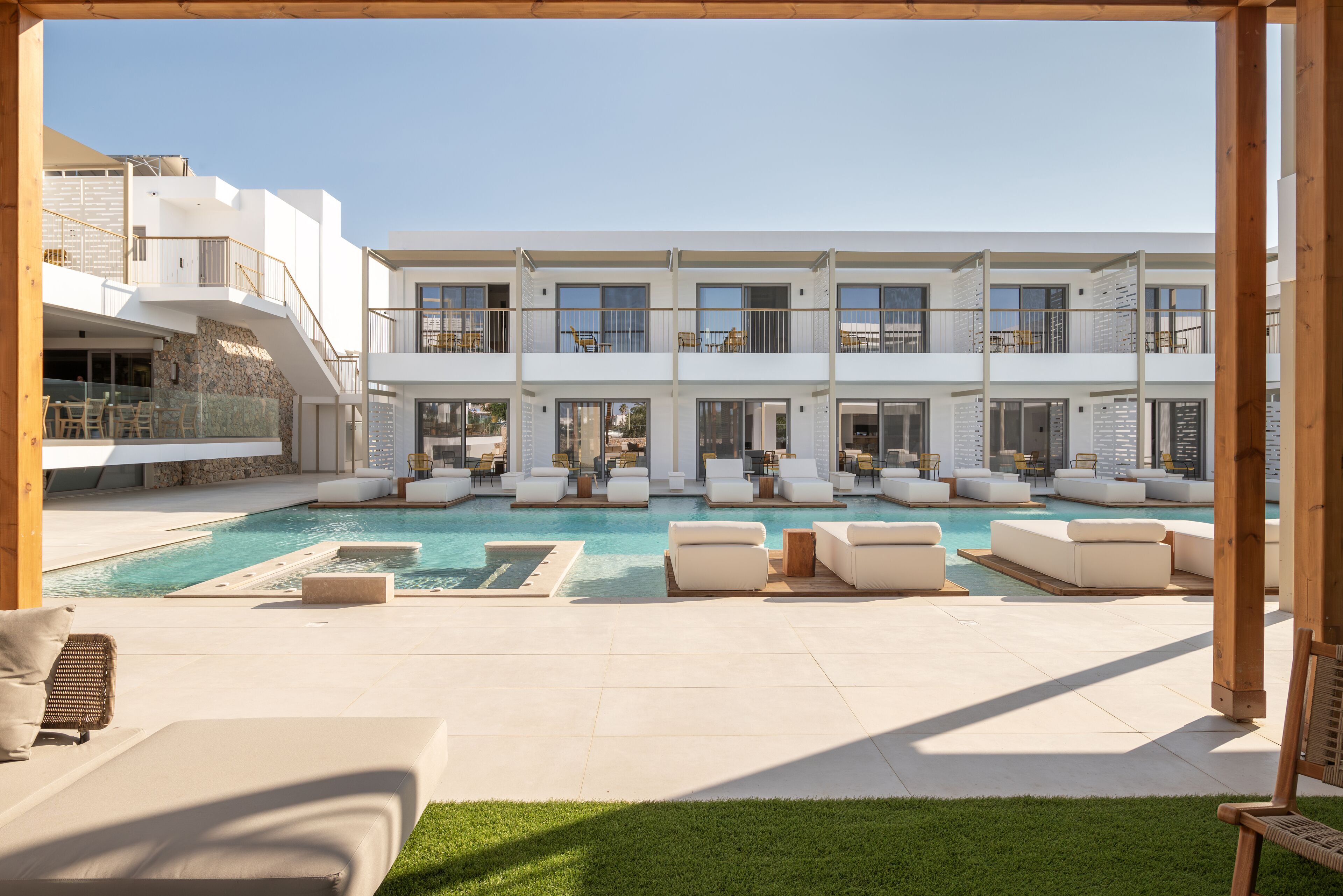 Un hôtel moderne doté d’une grande piscine extérieure, de nombreux balcons et d’espaces de détente en plein air.