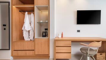 A modern room with a wooden wardrobe, a desk with a chair, and a mounted TV.