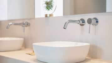 Ein modernes Badezimmer mit einem weißen Waschbecken und zwei Wasserhähnen.