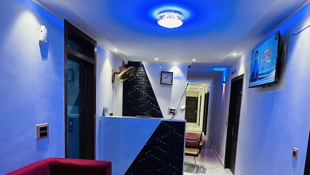 Um interior moderno com um sofá vermelho, uma escada e uma televisão na parede.