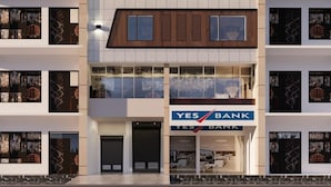 Um edifício de vários andares com uma placa indicando Hotel Katani Inn e Yes Bank.