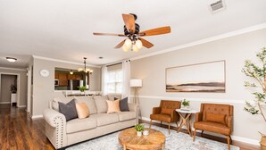 A living room with a beige sofa, two armchairs, a coffee table, and a ceiling fan. - Central 2BR/2BA | Pet Friendly | Fenced Yard (Warner Robins)