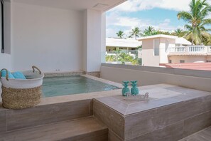 A balcony with a pool, a woven basket, and decorative items.