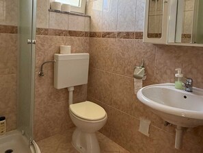 Ein Badezimmer mit Toilette, Waschbecken und Dusche.