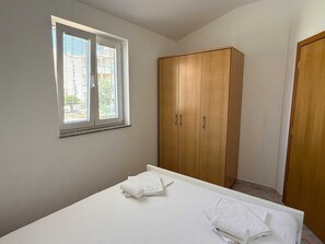 Ein Schlafzimmer mit einem Bett, einem Kleiderschrank und einem Fenster.