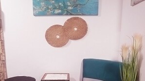 A room with a teal sofa, two black ottomans, a small side table, and a potted plant. - 10 minutes walk to North Park, 5 minutes to Beli Dunav metro station.  (Sofia)