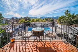 Eine Dachterrasse mit Pool, Sitzgelegenheiten im Freien und Blick auf die Berge.