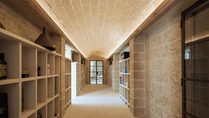 Un pasillo con estanterías blancas a ambos lados, que conduce a una puerta de vidrio al final.