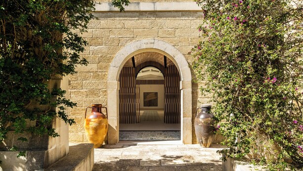 Un arco de entrada que da a una habitación con suelo estampado y vistas de otra habitación con suelo estampado.