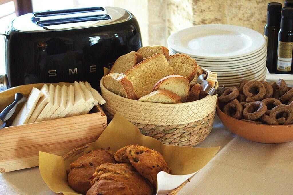 A breakfast buffet with bread, pastries, and a toaster.