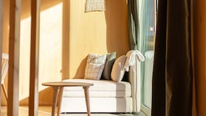 Een moderne woonkamer met een bank, een ronde tafel en een hanglamp.