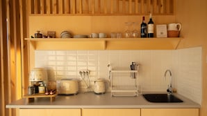 Een keuken met houten kastjes, een wit aanrecht, een spoelbak en diverse keukenapparaten.